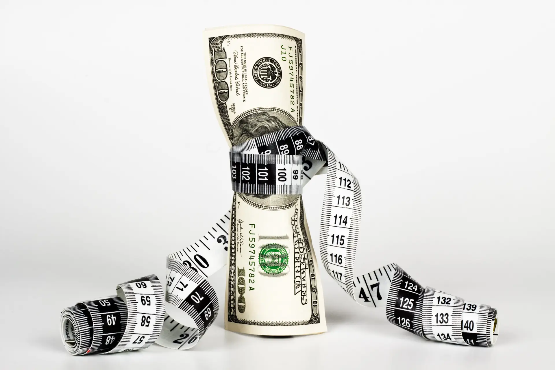 Measuring,A,Couple,Of,Dollar,Bills,With,A,Measure,Tape