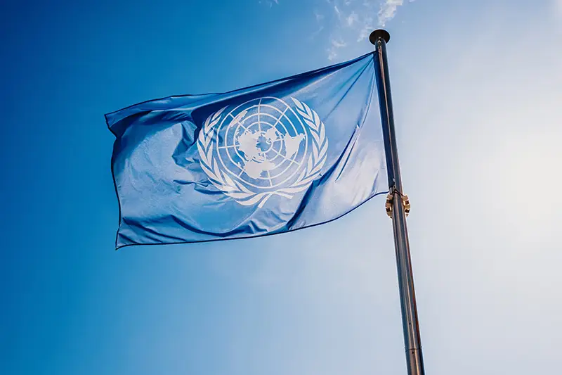 Un,Flag,Waved,Against,The,Sun,And,Blue,Sky.